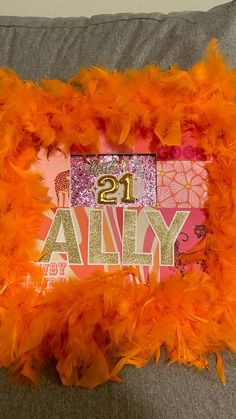 an orange feather frame with the number twenty one on it that says, 21 ally