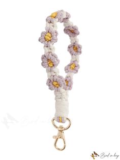 a white and yellow lanyard with flowers attached to it's end, on a metal hook