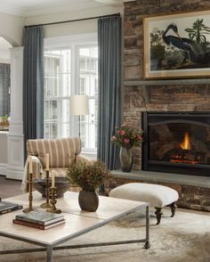 a living room filled with furniture and a fire place in front of a stone fireplace