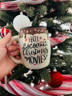 a hand holding a coffee mug with the words hot cocoa and christmas movies on it