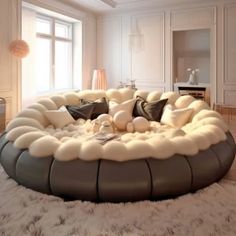 a living room filled with white furniture and lots of pillows on top of the floor