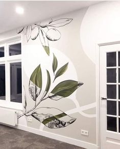 the wall is painted with flowers and leaves in an empty room next to two windows