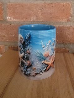 a blue glass vase sitting on top of a wooden table next to a brick wall