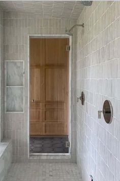 a white tiled bathroom with a wooden door