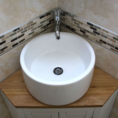 a white sink sitting on top of a wooden counter