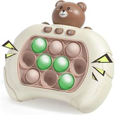 a teddy bear is sitting on top of an electronic device with green balls in it