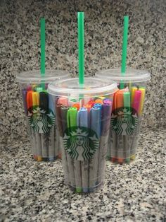 three starbucks cups with green straws on them