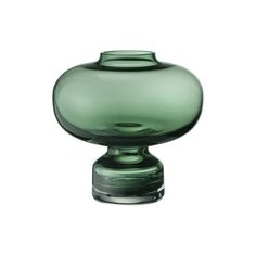 a green glass vase sitting on top of a table