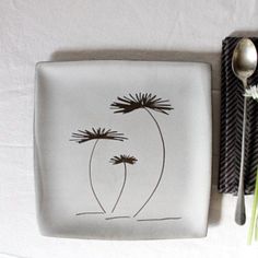 a white plate sitting on top of a table next to a fork and spoons