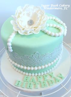 a green and white cake with a flower on top