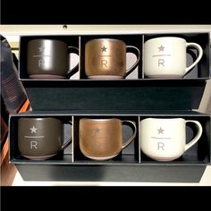 three coffee mugs are sitting in a box