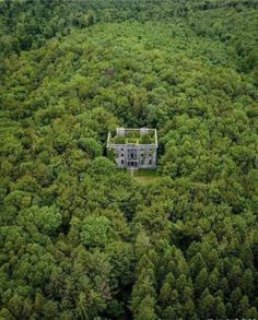 an aerial view of a house in the middle of a forest with lots of trees