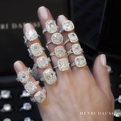 a woman's hand with five different rings on her fingers and four diamonds in the middle