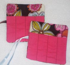 two pink and brown purses sitting next to each other on a white cloth covered surface