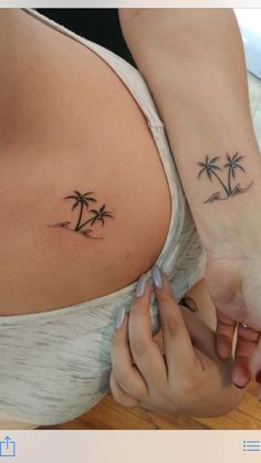 two people holding hands with tattoos on their stomachs and palm trees tattooed on them