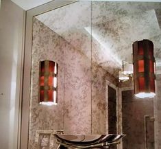 a bathroom sink sitting under a large mirror next to a light on top of a counter