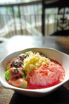 a white bowl filled with lots of different types of food on top of a wooden table