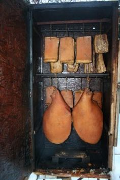 some kind of oven that is outside in the snow with gloves hanging from it's sides