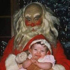 a baby is sitting in front of santa clause