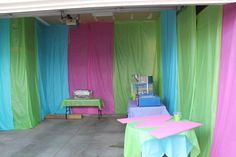 the room is decorated with colorful curtains and table cloths for an outdoor event or party