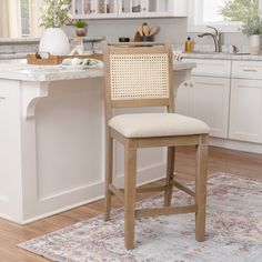 a kitchen with white cabinets and wooden stools