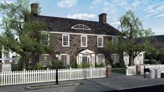 an artist's rendering of a large brick house with white picket fence and trees