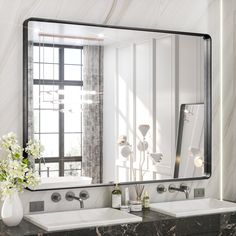 a bathroom vanity with two sinks and a large mirror above it, in front of a window