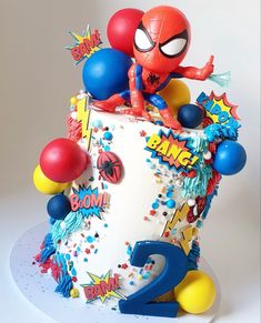 a spiderman birthday cake with balloons and confetti