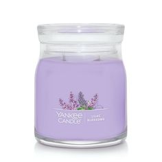 the yankee candle is purple and has lavender flowers on it's front, in a glass jar