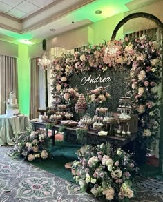 a table with flowers and desserts on it in front of a green wall that says auribea