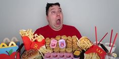 a man is holding up a tray of food with mcdonald's written on it