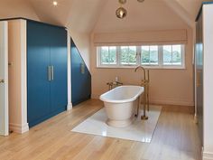 a bathroom with a large tub and blue cabinets