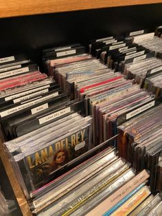 many cd's are stacked on top of each other in a shelf at the store