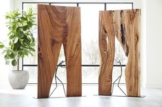 three pieces of wood sitting on top of a floor next to a potted plant