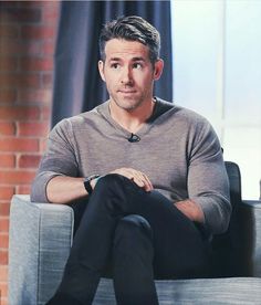 a man sitting on top of a gray couch