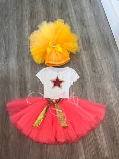 two pieces of clothing on the floor, one with a star and another with a red tutu