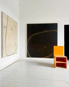 an empty room with two paintings on the wall