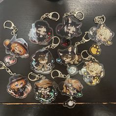 a bunch of key chains with anime characters on them sitting on top of a table