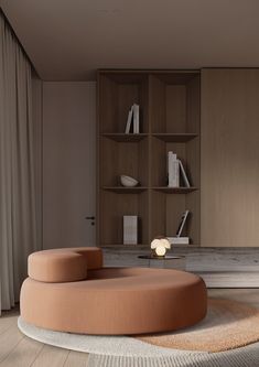 a living room with a round couch and bookshelf