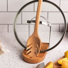 a wooden utensil holder with a knife and cheese slicer in front of it