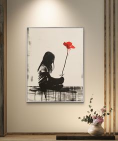 a woman sitting on a bench with a flower in front of her and the wall behind her