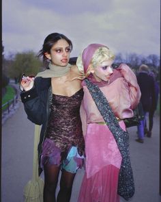 two women dressed in costumes walking down the street