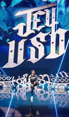 a man standing on top of a stage in front of a sign