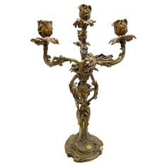 an ornately decorated candelabra with four candles in the shape of flowers