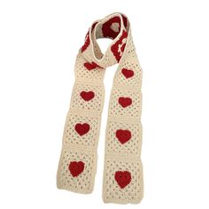 a white scarf with red hearts on it