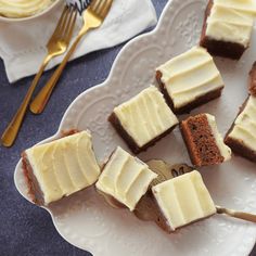 several pieces of cake on a white plate with fork and spoons next to it