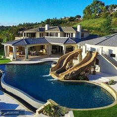 an aerial view of a large home with a pool and slide in the middle of it