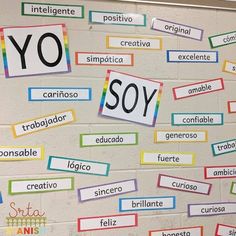 the word yo is written in many different languages on a white brick wall with multi - colored strips