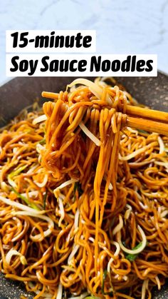 noodles with carrots and onions in a wok on a table top, ready to be eaten