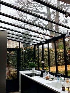 an outdoor kitchen with glass walls and windows